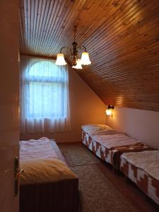 two beds in a room with a window at Almavilla in Gyenesdiás