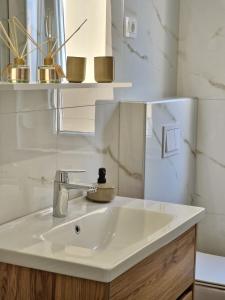een badkamer met een witte wastafel en een spiegel bij Apartment Lori in Matulji