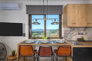 a kitchen with a table with chairs and a large window at MENTA lux apartment sea view in Asgourou