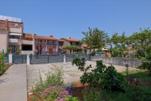 uitzicht op een tuin met huizen en bloemen bij Apartman Mishel 1 Fazana in Fažana