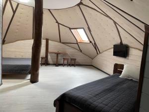 a room with a bed and a tv in a attic at Kolyba Club in Stanishovka