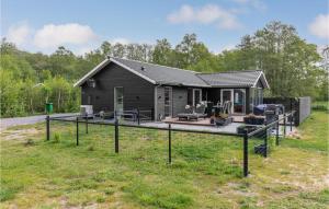 a house with a large deck in the yard at Nice Home In Aakirkeby With Wifi And 3 Bedrooms in Vester Sømarken