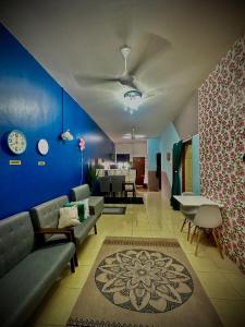 a living room with a couch and a blue wall at AD Homestay Gua Musang Terrace House with 3 room in Gua Musang