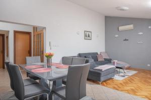 a living room with a table and a couch at Villa Sorelle with a swimming pool in Kastel Stari