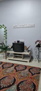 sala de estar con TV y alfombra en DHut Homestay puncak iskandar, en Seri Iskandar