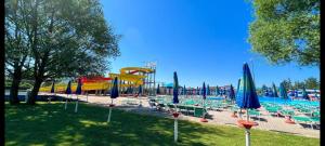 uma piscina com um parque aquático com cadeiras e guarda-sóis em Piccoli Desideri Tra le Singolarità del Molise em Forlì del Sannio