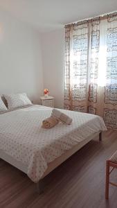 1 dormitorio con 1 cama con sábanas y cortinas blancas en Relax en Preko
