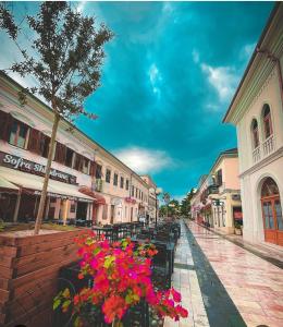 a city street with tables and flowers and buildings at Bala Apartment in Shkodër +5 photos