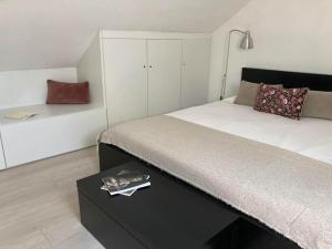 ein Schlafzimmer mit einem großen Bett und einem Tisch in der Unterkunft Gafa House - Family Accommodation and Workplace in Gafanha da Nazaré