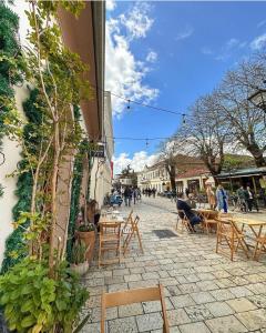 a cobblestone street with tables and chairs next to a building at Bala Apartment in Shkodër