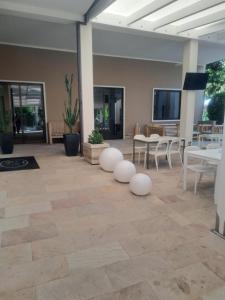 a lobby with white tables and white chairs and tables at Hotel Trieste in Senigallia