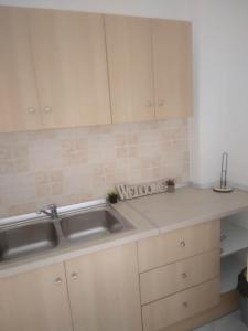 a kitchen with white cabinets and a sink at RIVER SIDE HOUSE in Potámion