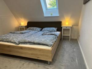 Bett in einem Zimmer mit 2 Tischen und einem Fenster in der Unterkunft Ferienhaus Beerennest in Butjadingen