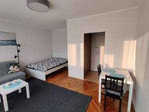 una pequeña sala de estar con cama y mesa. en Słoneczna kawalerka, en Gdansk