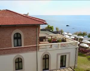 a building with a balcony with the ocean in the background at Cala Dei Mori in Livorno