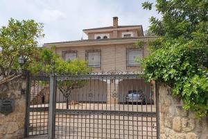 a gate in front of a house with a fence at EMENTA CB in Córdoba