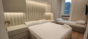 - une petite chambre avec 2 lits et une fenêtre dans l'établissement Marcora 6 v luxury living, à Milan