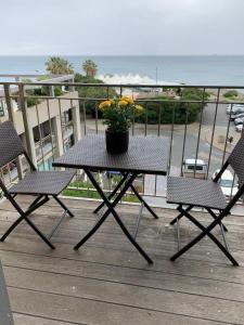 einen Tisch mit zwei Stühlen und eine Topfpflanze auf dem Balkon in der Unterkunft Casa "il Gabbiano Blu" in Savona