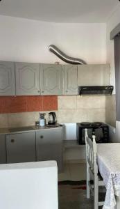 a kitchen with white cabinets and a table and a stove at Tasos_Studios&Apartments 2 in Kranidi