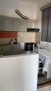 a kitchen with white cabinets and a table in it at Tasos_Studios&Apartments 2 in Kranidi