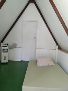 Kleines Zimmer mit einem Bett und einer Tür in der Unterkunft Ohana Resort 