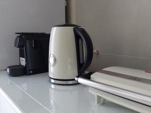 a coffee maker sitting on a counter next to a microwave at Eva's apartment in Karistos