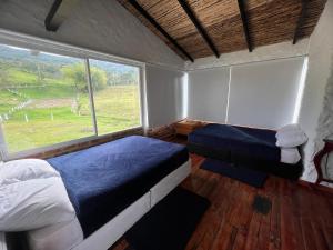 a bedroom with two beds and a large window at Caney 2 in Moniquirá