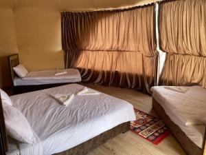 a hotel room with two beds and a window at Al Rifi Luxury Camp in Wadi Rum