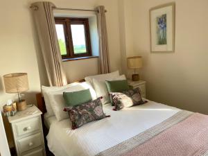 een slaapkamer met een bed met 2 kussens en een raam bij Grovetown Barn in Launceston