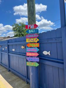 una señal en un poste con señales en una valla en Blue Little Havana en Miami