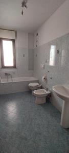 a bathroom with two toilets and a tub and a sink at Perugino Apartament in Florence