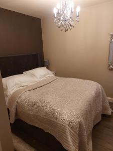 a bedroom with a bed with a chandelier at Romeo & Juliet's with Private Parking in Stratford-upon-Avon