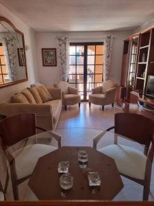 - un salon avec un canapé, des chaises et une table dans l'établissement Pueblo Mascarat, 50 m al mar, 3 piscios, à Altea la Vieja