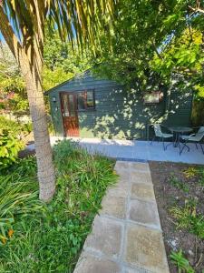 a house with a palm tree and a patio at Picturesque Cabin in Cornwall in Camborne