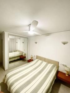 - une chambre blanche avec un lit et un miroir dans l'établissement Pueblo Mascarat, 50 m al mar, 3 piscios, à Altea la Vieja