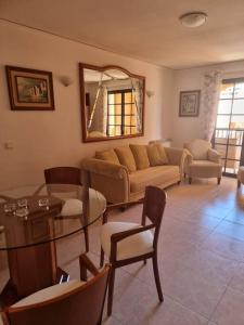 - un salon avec un canapé et une table dans l'établissement Pueblo Mascarat, 50 m al mar, 3 piscios, à Altea la Vieja