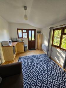 a living room with a blue and white rug at Picturesque Cabin in Cornwall in Camborne