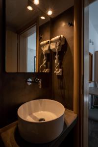 W łazience znajduje się umywalka i lustro. w obiekcie Liana Studios w mieście Mykonos