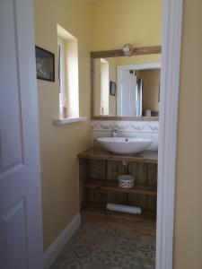 ein Bad mit einem Waschbecken und einem Spiegel in der Unterkunft Beautiful one bed apartment with stunning sea view in Waterford