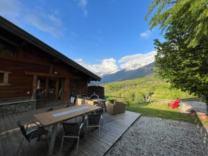 a patio with a table and chairs in front of a cabin at CHALET TOUDBIOLE haut de chalet in Les Houches