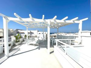 a white pergola on the roof of a house at Villa Azzurra in Marina di Mancaversa