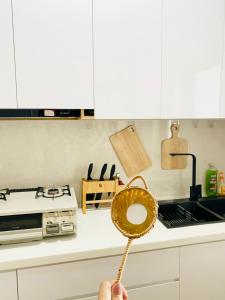 a person holding a wooden spoon in a kitchen at Căn hộ ngắn hạn Thành phố Hồ Chí Minh Gần sân bay in Ho Chi Minh City