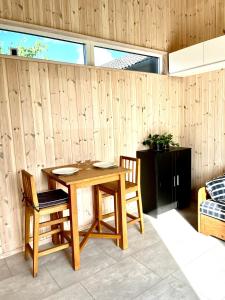 a wooden table with two chairs and a wooden wall at Neptuni Bed and Kitchen in Varberg