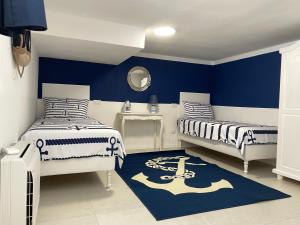 a bedroom with two beds and a blue wall at Casa Morandi MARE in San Vincenzo