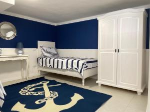 a bedroom with a bed and a blue wall at Casa Morandi MARE in San Vincenzo