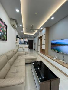 sala de estar con sofá grande y TV en Căn hộ ngắn hạn Thành phố Hồ Chí Minh Gần sân bay, en Ho Chi Minh