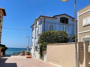 un edificio azul en una calle junto al océano en Casa Morandi MARE en San Vincenzo