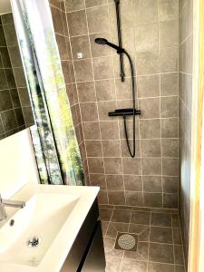 W łazience znajduje się prysznic i umywalka. w obiekcie Neptuni Bed and Kitchen w mieście Varberg