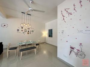 una sala da pranzo con tavolo, sedie e parete con farfalle di Homely, S2 City Center, WiFi, Guarded Community a Seremban