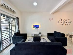 uma sala de estar com dois sofás e uma televisão em Homely, S2 City Center, WiFi, Guarded Community em Seremban